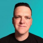 A man with short, dark hair and fair skin is smiling slightly, facing the camera. He is wearing a black shirt against a solid teal background, evoking confidence—perfect for discussions about GraphQL & gRPC API Security.